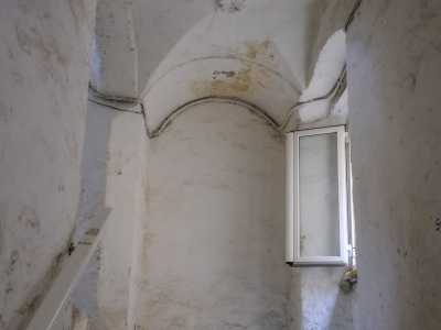 Raggiungiamo lo stretto vano scala dell�immobile con pareti e soffitto coperti da vari strati di intonaco bianco